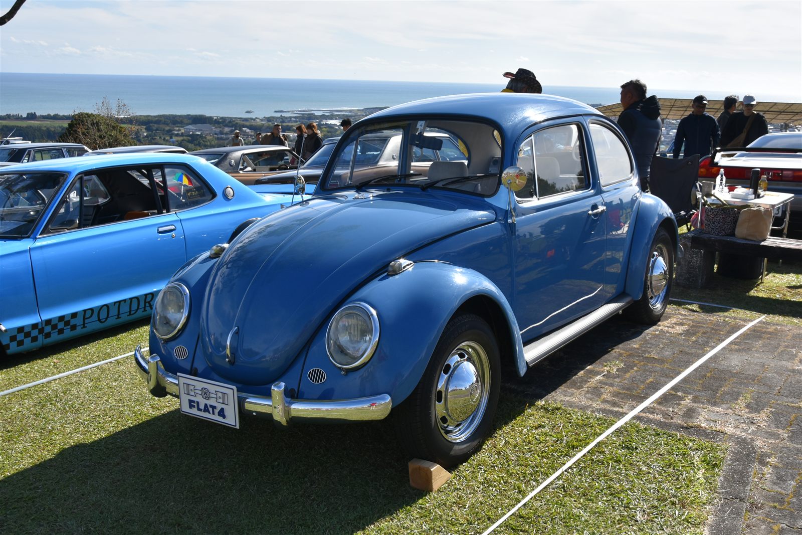 海を背にした青いフォルクスワーゲン・ビートル(2024年)